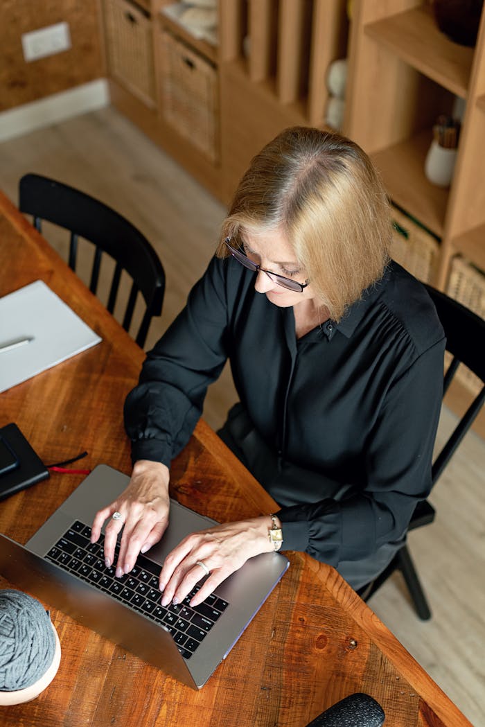 Blonde businesswoman working on laptop, showcasing professionalism and career focus.